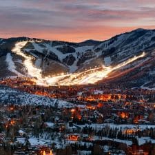 A night time photo overlooking Park City, Utah with illuminated ski hills in the background